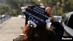 FILE - Student Marie Nangaray Saucedo, 52, takes part in a drive-through graduation at Rio Hondo community college, as the COVID-19 pandemic continues, in Whittier, near Los Angeles, California, May 28, 2021.