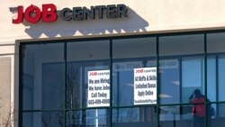 FILE - A man walks past the signs of an employment agency, March 2, 2021, in Manchester, N.H.