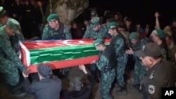 In this image taken from video, servicemen carry a coffin of Azeri serviceman Shamistan Sadykhov killed in new fighting at Azerbaijani-Armenian border, during his funeral in Lerik, Azerbaijan, Sept. 13, 2022.