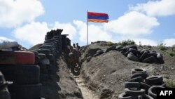 Tentara berjalan di parit di pos pemeriksaan perbatasan antara Armenia dan Azerbaijan di dekat desa Sotk, Armenia, pada 18 Juni 2021. (Foto: AFP/Karen MINASYAN)