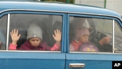 Children look through a car windows as they and other refugees from Kharkov Region of Ukraine come to temporary camp in Belgorod, Russia, Sept. 14, 2022. Thousands fled fled northeastern Ukraine to Russia amid Ukrainian counteroffensive in the region.