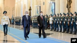 Chinese President Xi Jinping, right, and Kazakhstan's President Kassym-Jomart Kemeluly Tokayev review an honor guard during a welcome ceremony at the Ak Orda Presidential Palace in Nur-Sultan, Kazakhstan, Sept. 14, 2022. (Xinhua via AP)