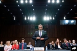 Twitter whistleblower Peiter Zatko buttons his jacket as he rises to be sworn in to testify to a Senate Judiciary hearing examining data security at risk, in Washington, Sept. 13, 2022.