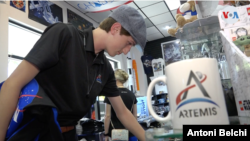 Un joven turista que viajó hasta Cabo Cañaveral para ver el lanzamiento de la misión Artemis compra algunos artículos de recuerdo de este día. [Foto: Antoni Belchi / VOA]