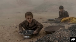 FILE - Afghan children work in a brick factory on the outskirts of Kabul, Afghanistan, Aug. 20, 2022.