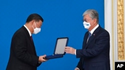 Kazakhstan's President Kassym-Jomart Kemeluly Tokayev, right, presents Chinese President Xi Jinping with his nation's highest state award during their meeting in Nur-Sultan, Kazakhstan, Sept. 14, 2022. (Kazakhstan president's press-service via AP)