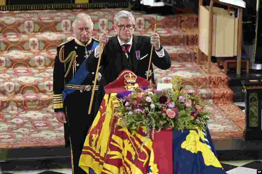 King Charles II, left, watches as The Lord Chamberlain Baron Parker breaks his Wand of Office, marking the end of his service to the sovereign, during the Committal Service for Queen Elizabeth at St. George's Chapel, Windsor Castle in Windsor, Sept. 19, 2022.