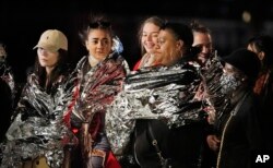 FILE- People in warming foil queue to pay their respect to the late Queen Elizabeth II outside Westminster Hall in London, Sept. 16, 2022.