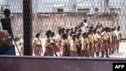 FILE - Pupils stand in line in their school's courtyard in Douala, western Cameroon, on Jan. 13, 2022. Officials in the country say separatist attacks and threats have shut down scores of schools since the school year started on Sept. 5, 2022. 