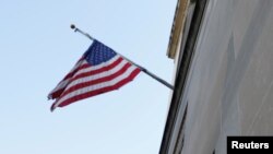 FILE - A U.S. flag flies in front of the Department of Justice building in the U.S. capital of Washington. On Monday, a Canadian man was sentenced to 20 years in prison in the United States for providing assistance to the Islamic State group in Syria. 