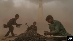 FILE - Afghan children work in a brick factory, on the outskirts of Kabul, Afghanistan, Aug. 20, 2022.