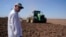 Farmer Larry Cox watches a tractor at work on a field at his farm Aug. 15, 2022, near Brawley, Calif. 