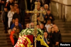 Members of the public pay their respects as they pass the coffin of Queen Elizabeth II, lying in state in Westminster Hall, at the Palace of Westminster, London, Sept. 15, 2022.