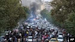 FILE - In this photo taken by an individual not employed by AP and obtained by the AP outside Iran, protesters chant slogans during a protest over the death of a woman who was detained by the morality police, in downtown Tehran, Sept. 21, 2022.