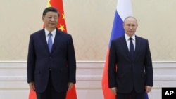 FILE- Chinese President Xi Jinping, left, and Russian President Vladimir Putin pose on the sidelines of the Shanghai Cooperation Organization (SCO) summit in Samarkand, Uzbekistan, Sept. 15, 2022.