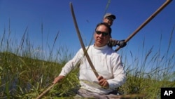 Ryan White, front, and Darold Madigan harvest wild rice on Leech Lake in Minnesota, Sept. 11, 2022.