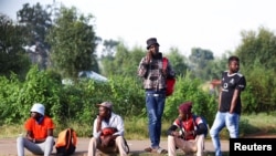 FILE - Job seekers wait beside a road for casual work offered by passing motorists in Eikenhof, south of Johannesburg, South Africa, March 3, 2022.