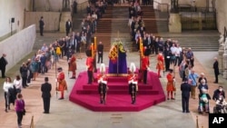 The first members of the public pay their respects as the vigil begins around the coffin of Queen Elizabeth II in Westminster Hall, London, Sept. 14, 2022, where it will lie in state ahead of her funeral on Monday.