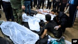A man is being comforted by an another man as he sits next to the body of his loved who was killed in the explosions in the city of Kerman, about 820 kms southeast of the capital Tehran, Iran, Jan. 3, 2024. 