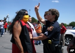 A Rapid City police officer stops a woman during a protest against anti-Native racism in May, 2012.