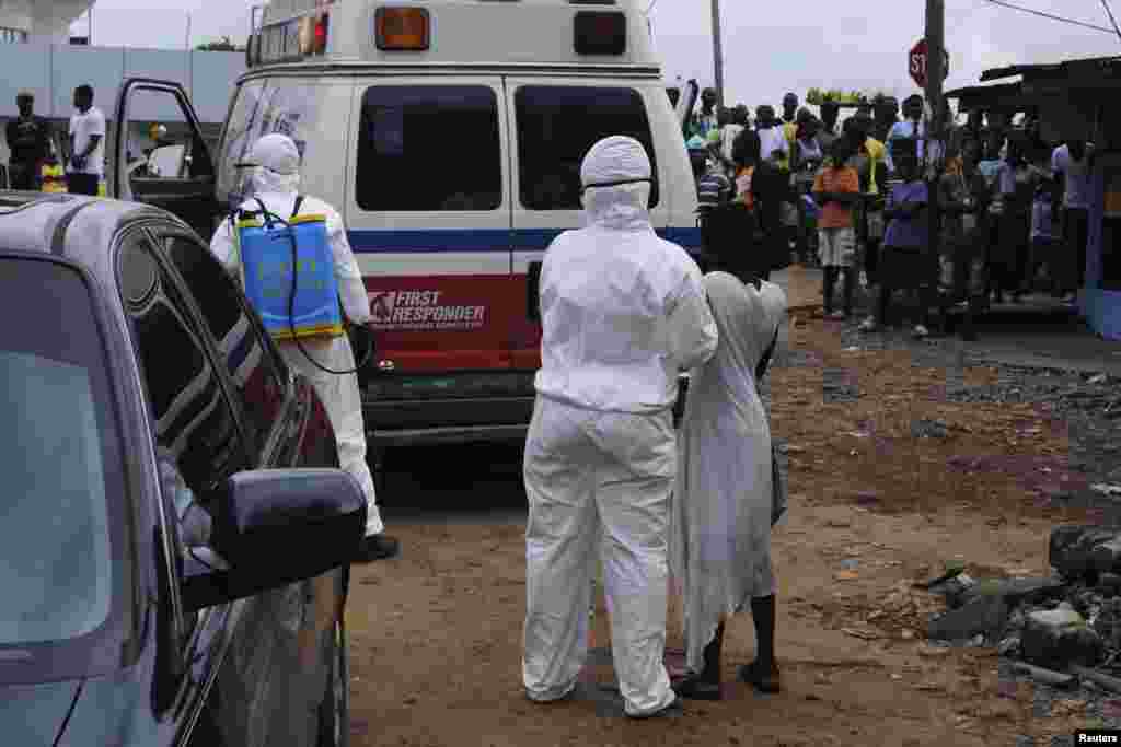 Health workers bring a woman suspected of having contracted Ebola virus to an ambulance in Monrovia, Liberia, Sept. 15, 2014.