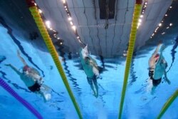 From left to right, Britain's Duncan Scott, South Korea's Hwang Sunwoo and Britain's Tom Dean swim in a 200-meter freestyle semifinal at the 2020 Summer Olympics, July 26, 2021, in Tokyo.