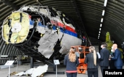 Presiding Judge Hendrik Steenhuis inspects the reconstruction of the MH17 wreckage, as part of the murder trial, in Reijen, Netherlands, on May 26, 2021. (Piroschka van de Wouw/Reuters)