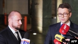 Jacek Siewiera, head of Poland's Office of National Security, left, and Polish government spokesman Piotr Muller speak after a security office meeting in Warsaw, Nov. 15, 2022. Poland put its military on alert Nov. 14 after a missile landed inside its borders, killing two people.