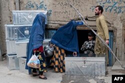 Para perempuan Afghanistan sedang melihat-lihat peti di sebuah bengkel di Kabul, Afghanistan, 15 November 2022. (Foto: Wakil Kohsar/AFP)