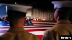 FILE - Army members hold the U.S. flag as they attend an annual Memorial Day ceremony at the Intrepid Museum in New York, May 29, 2017. The Pentagon has just revised a program that enables foreign-born military recruits to earn a fast-track path to American citizenship.