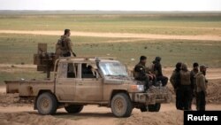 Members of Syrian Democratic Forces (SDF) stand together near Baghouz, Deir el-Zour province, Syria, Feb. 11, 2019. 