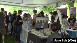 One Journey festival attendees drop by a tent to gather information that was set up by one of many participating non-profit organizations that help refugees.