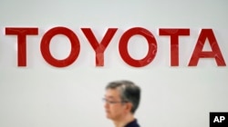 A visitor walks through a Toyota showroom in Tokyo, Aug. 3, 2018.