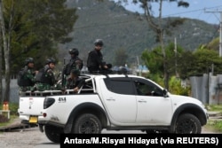 Tentara dan polisi duduk di atas mobil saat berpatroli di Wamena, Papua, 9 Oktober 2019. (Foto: Antara/M.Risyal Hidayat via REUTERS)