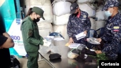 Guardias analizan estupefacientes decomisados en la Superintendencia Nacional Antidrogas en el estado Anzoátegui, Venezuela, el 28 de diciembre de 2021. [Foto: Cortesía de la Superintendencia Nacional Antidrogas]