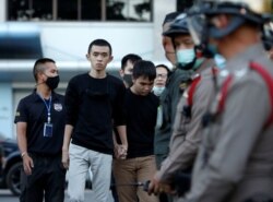 Pro-democracy leaders Tattep Ruangprapaikitseree and Panumas Singprom walk to meet with the media after being granted bail, outside the criminal court in Bangkok, Thailand, Aug. 26, 2020.