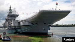 Indian Navy officers stand on the flight deck of India's first home-built aircraft carrier INS Vikrant after its commissioning ceremony at a state-run shipyard in Kochi, India, Sept. 2, 2022.