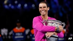 Petenis Spanyol Rafael Nadal dengan trofi juara Australia Terbuka tahun 2022, gelar grand slamnya yang ke-21, Minggu (30/1). 