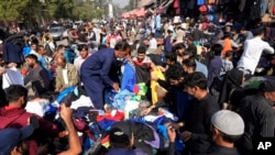 Warga Pakistan berbelanja di Lahore, Pakistan, Senin, 13 November 2022. Populasi dunia diproyeksikan mencapai sekitar 8 miliar orang pada Selasa, 15 November, menurut proyeksi PBB. (AP/K.M. Chaudary)