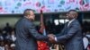 FILE - Outgoing Kenya President Uhuru Kenyatta shakes hands with President William Ruto at the Moi International Sports Center, in Nairobi, Kenya, Sept. 13, 2022, during Ruto's inauguration.