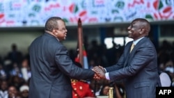 FILE - Outgoing Kenya President Uhuru Kenyatta shakes hands with President William Ruto at the Moi International Sports Center, in Nairobi, Kenya, Sept. 13, 2022, during Ruto's inauguration.