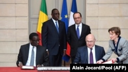 Le ministre français des Finances Michel Sapin (avant, au centre) et le ministre sénégalais de l'Economie, des Finances et de la Planification Amadou Ba signent des protocoles financiers à l'Elysée à Paris, le 20 décembre 2016.