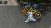 A worker wearing personal protective equipment walks on a street during a COVID-19 coronavirus lockdown in the Jing'an district in Shanghai on April 25, 2022. 