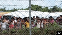FILE - Displaced Rohingya are seen in a fenced-in camp during a government-organized media tour to a no-man's land between Myanmar and Bangladesh, near Taungpyolatyar village, Maung Daw, northern Rakhine State, Myanmar, June 29, 2018.