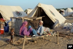 A family take refuge after heavy rains in Sohbat Pur city, a district of Pakistan's southwestern Baluchistan province, Sept. 4, 2022.