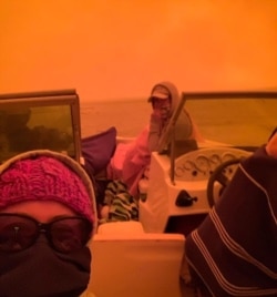 People evacuating on boat in Mallacoota, Victoria, are seen is this still image from a Dec. 31, 2019 social media video. (INSTAGRAM @IDASHOPE4STROKE via Reuters)