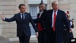 President Donald Trump is greeted by French President Emmanuel Macron after arriving at the Elysee Palace in Paris, Nov. 10, 2018. 
