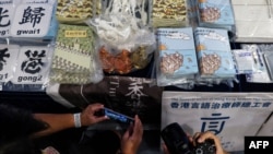 FILE: Members of the media take photos of evidence on display, including children's books trying to explain the city's democracy movement, at a police press conference in Hong Kong on July 22, 2021, after five members of a pro-democracy Hong Kong union w