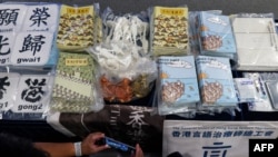 FILE - Members of the media take photos of evidence, including children's books trying to explain the city's democracy movement, at a police press conference in Hong Kong, July 22, 2021, after five people were charged with sedition for publishing the titles. 
