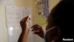 FILE - A nurse fills a syringe with malaria vaccine before administering it to an infant at the Lumumba Sub-County hospital in Kisumu, Kenya, July 1, 2022. 
